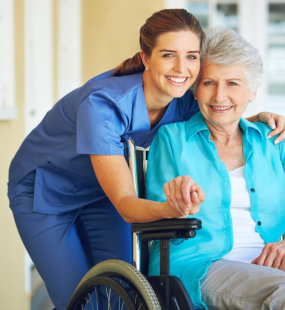 aide and senior woman smiling together