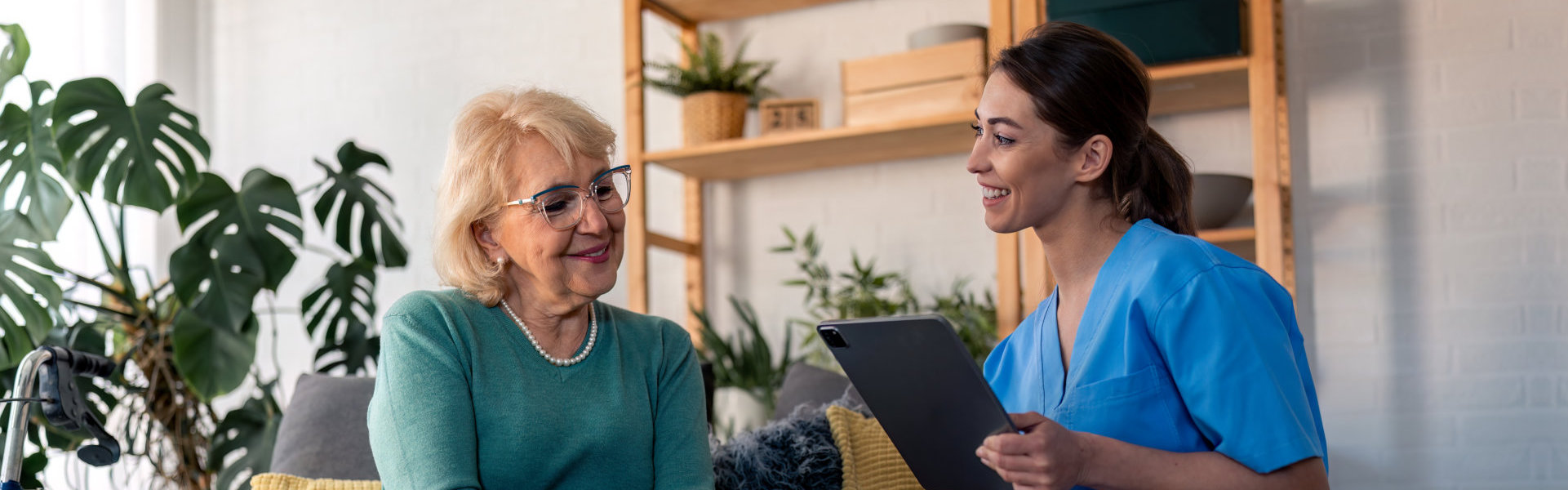 aide and senior woman smiling while having a conversation