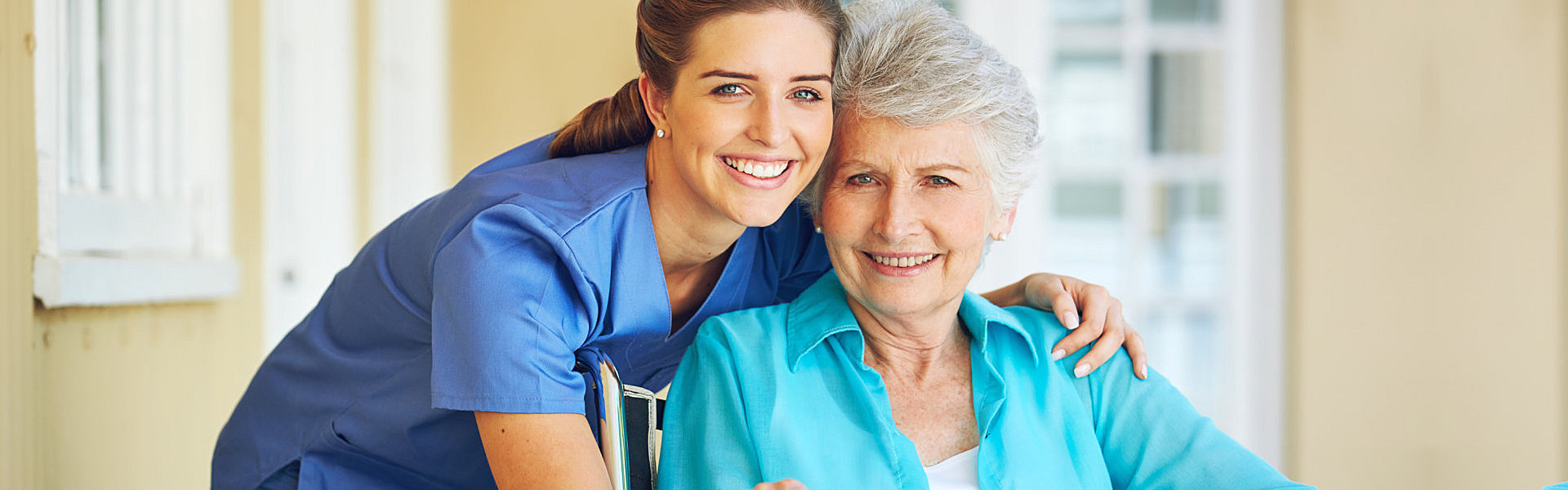 aide and senior woman smiling together