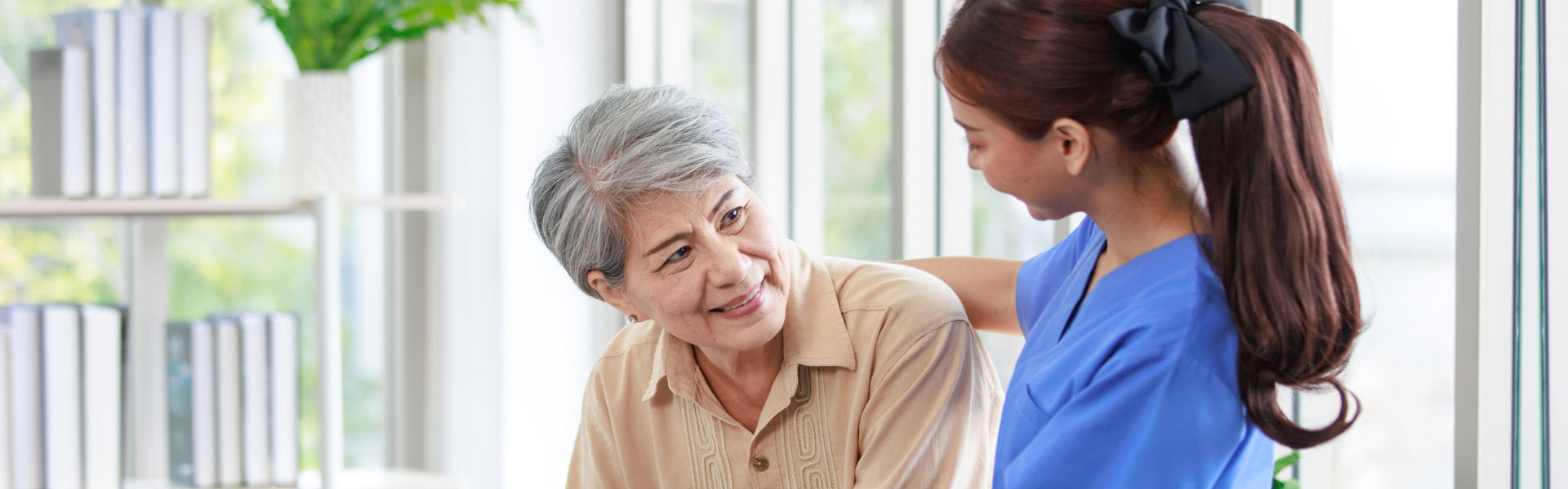 aide and senior woman looking at each other